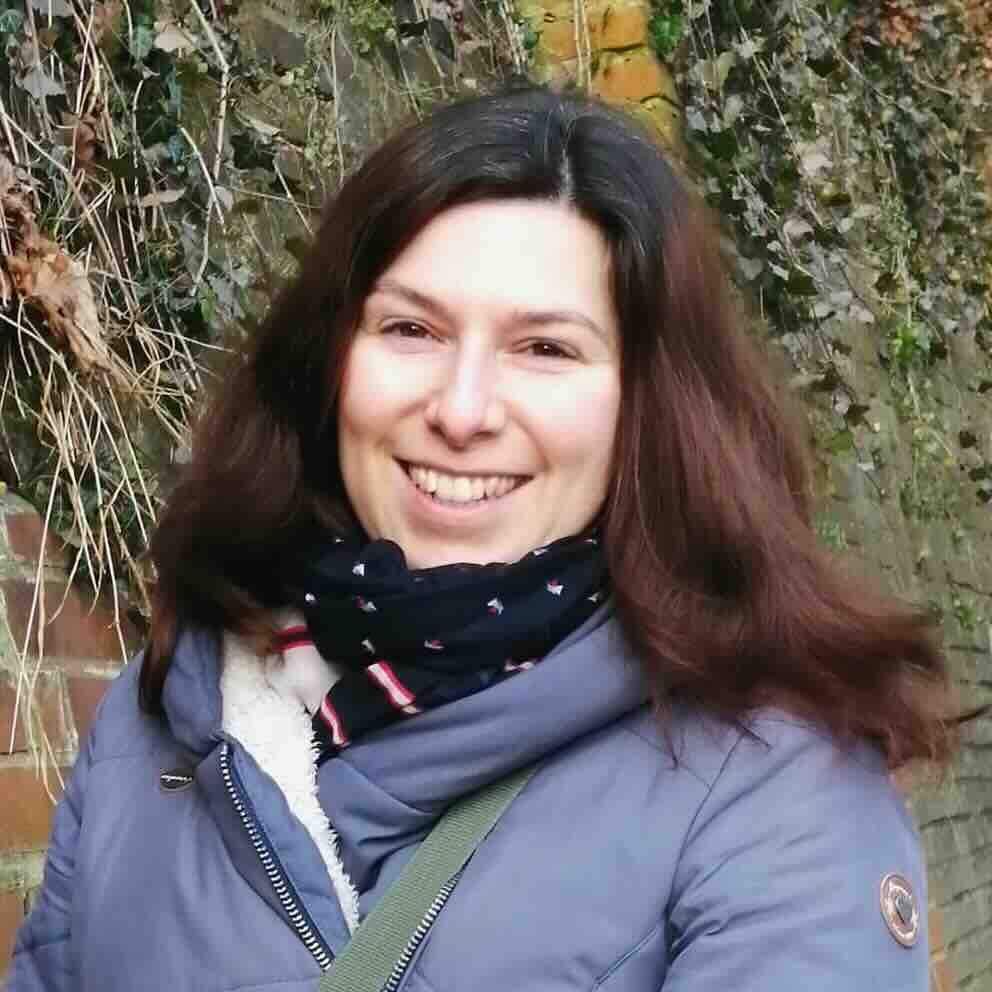 Engelkarten-Seminar-strahlende-Claudia-an-eine-Mauer-mit-Pflanzen-gelehnt